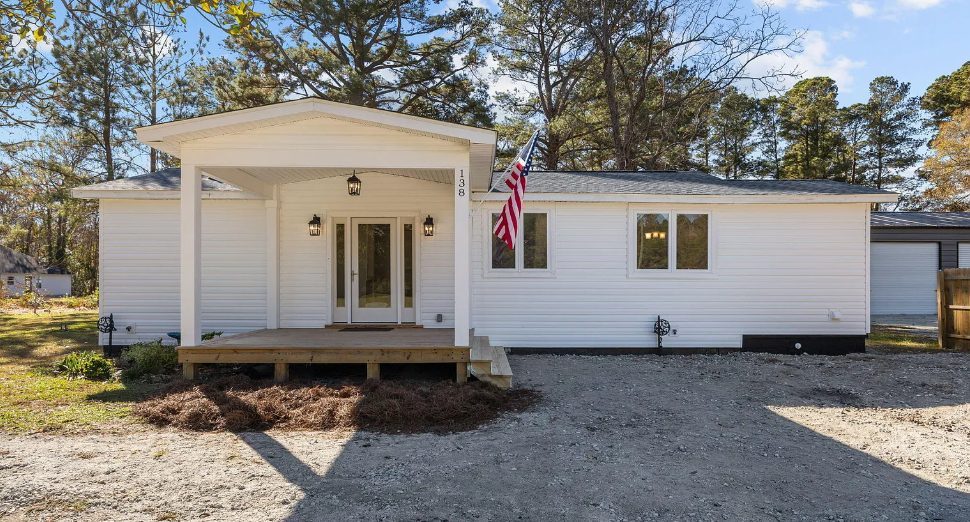 Fully remodeled white home with a front porch and American flag